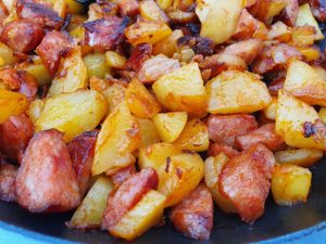 Brasede kartofler med løg og pølser - opskrift